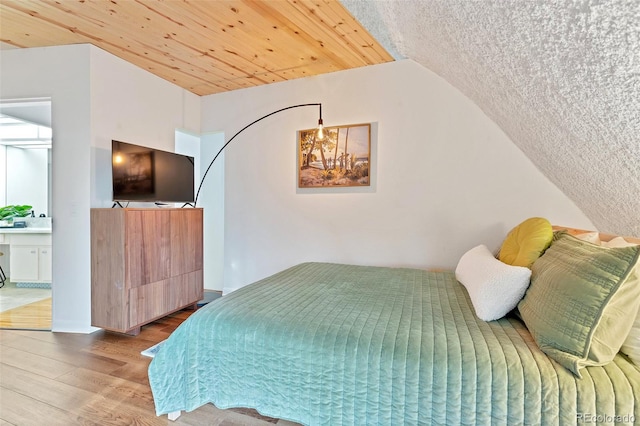 6681 S Abilene Way, Centennial, CO 80111 - bedroom featuring lofted ceiling, a notable chandelier, connected bathroom, and wood finished floors