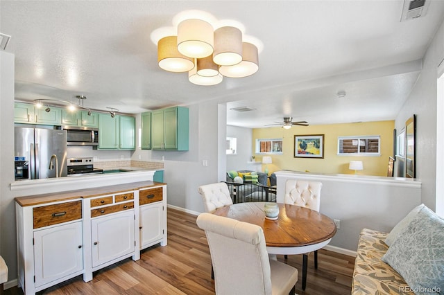 dining room with ceiling fan, baseboards, visible vents, and light wood-style floors