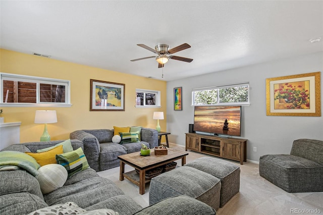living room featuring a ceiling fan, light carpet, visible vents, and baseboards
