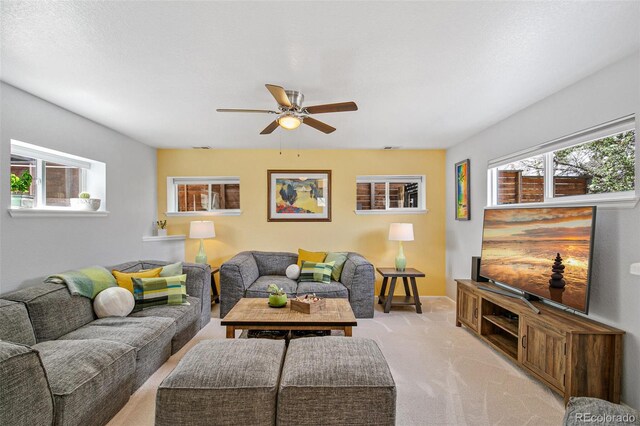 living room featuring light colored carpet and a ceiling fan