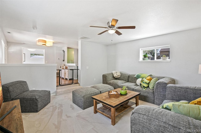 carpeted living room with a ceiling fan and visible vents