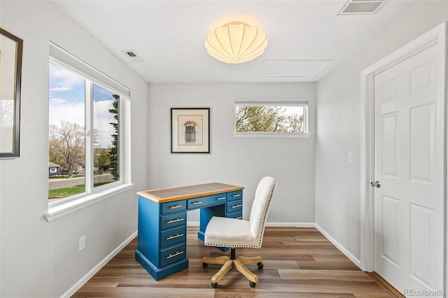 office area with baseboards, visible vents, and wood finished floors