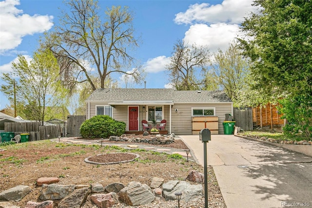 ranch-style home with covered porch, fence, and driveway
