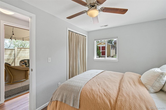 bedroom featuring baseboards, light wood-style floors, visible vents, and a ceiling fan