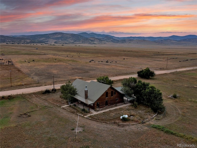 aerial view at dusk with a mountain view and a rural view