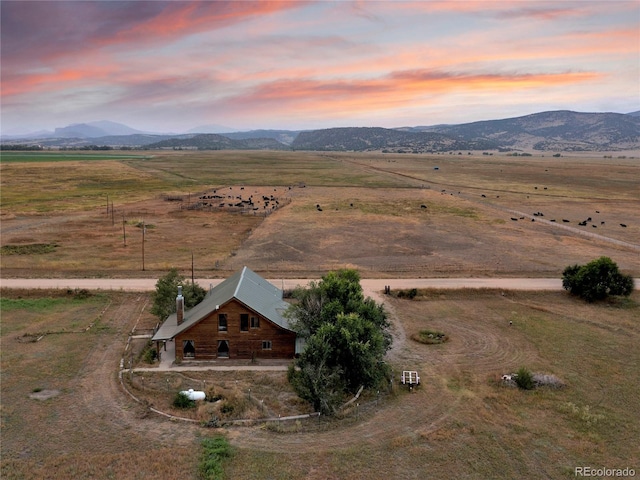 aerial view at dusk with a mountain view and a rural view