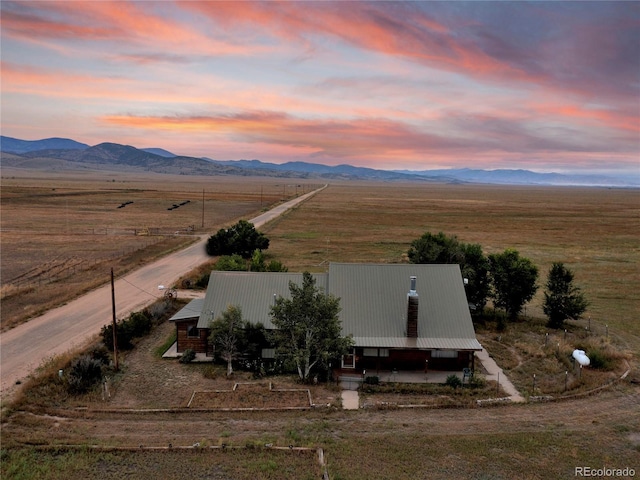 aerial view at dusk with a mountain view and a rural view