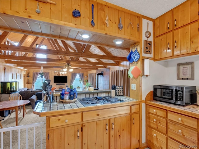 kitchen featuring tile countertops, kitchen peninsula, wood ceiling, and appliances with stainless steel finishes