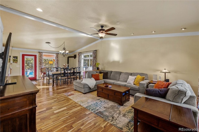 living room with ceiling fan with notable chandelier, light wood-type flooring, crown molding, and vaulted ceiling