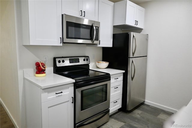 kitchen with white cabinetry, appliances with stainless steel finishes, and dark hardwood / wood-style flooring