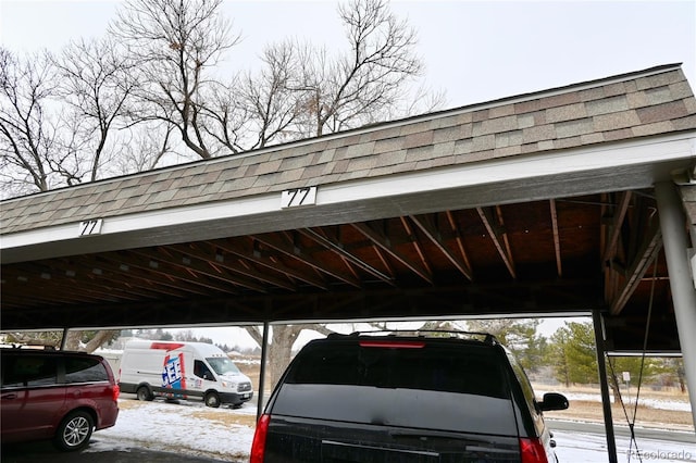 snow covered parking featuring a carport