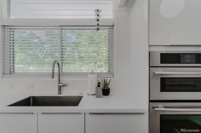 kitchen with white cabinets, sink, and double oven