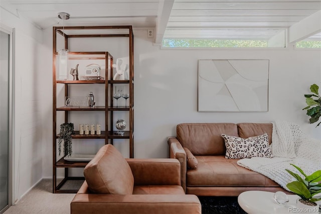 carpeted living room featuring beamed ceiling