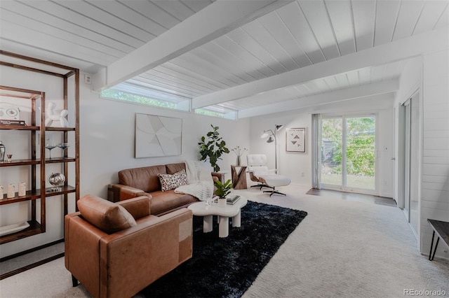 carpeted living room with beam ceiling