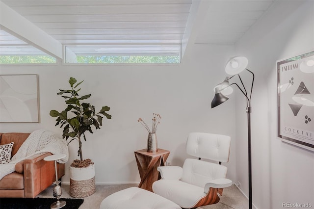 living area with carpet flooring and beamed ceiling