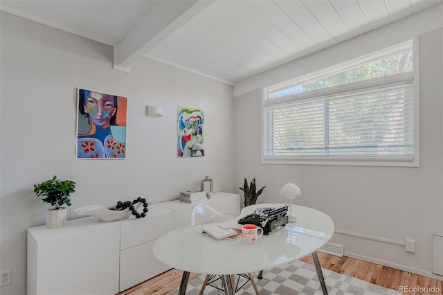 dining area featuring beamed ceiling and light hardwood / wood-style flooring