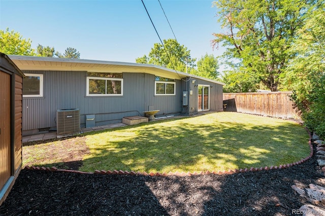 back of property with a lawn and cooling unit