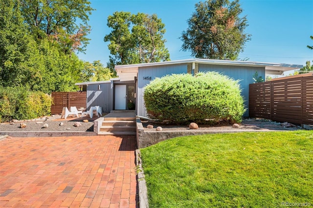 view of front of home with a front lawn and a patio