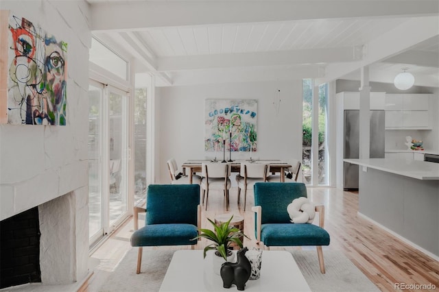 sitting room featuring light wood-type flooring and beam ceiling