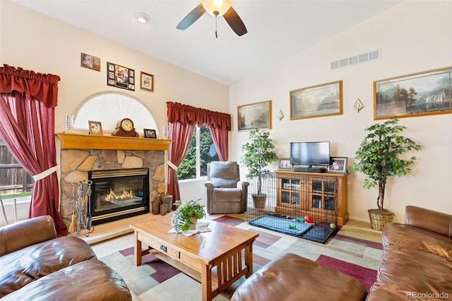 living room with a wealth of natural light, lofted ceiling, ceiling fan, and a fireplace