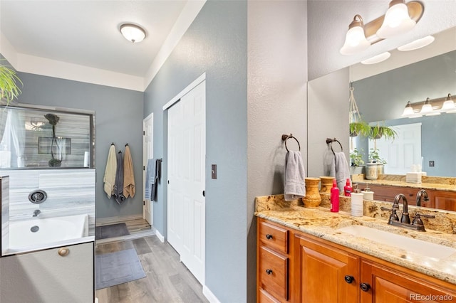 bathroom featuring vanity, plus walk in shower, and hardwood / wood-style flooring