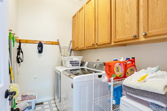 laundry room featuring cabinets and washer and dryer