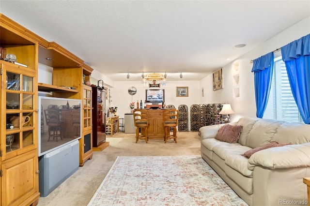 carpeted living room with a textured ceiling and bar