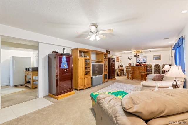 living room featuring ceiling fan, a textured ceiling, carpet, and indoor bar