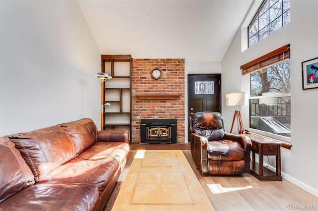 living area with a brick fireplace, wood finished floors, baseboards, and high vaulted ceiling