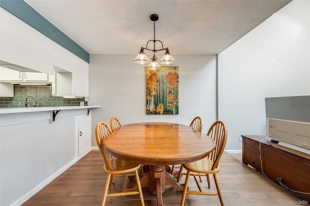 dining room featuring an inviting chandelier, baseboards, and light wood finished floors