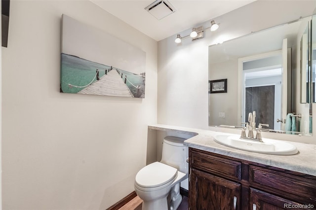 bathroom with visible vents, toilet, and vanity