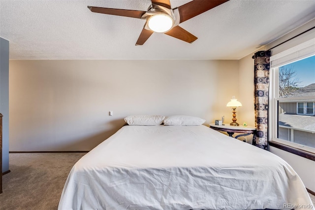 carpeted bedroom featuring baseboards, a textured ceiling, and ceiling fan