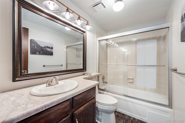 full bathroom featuring vanity, toilet, visible vents, and shower / bath combination with glass door