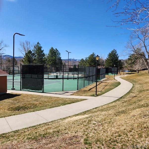 view of sport court featuring a lawn and fence