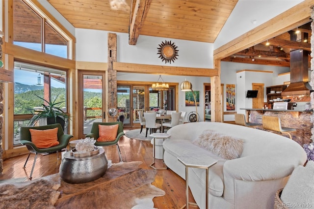 living room featuring wood ceiling, high vaulted ceiling, a mountain view, hardwood / wood-style flooring, and beam ceiling