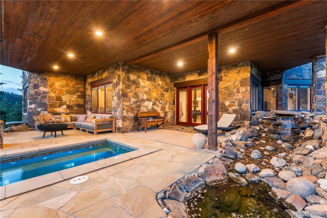 view of swimming pool with an outdoor living space with a fire pit, a patio area, and french doors