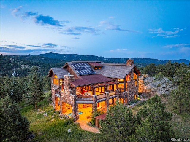 rear view of house with solar panels and a mountain view