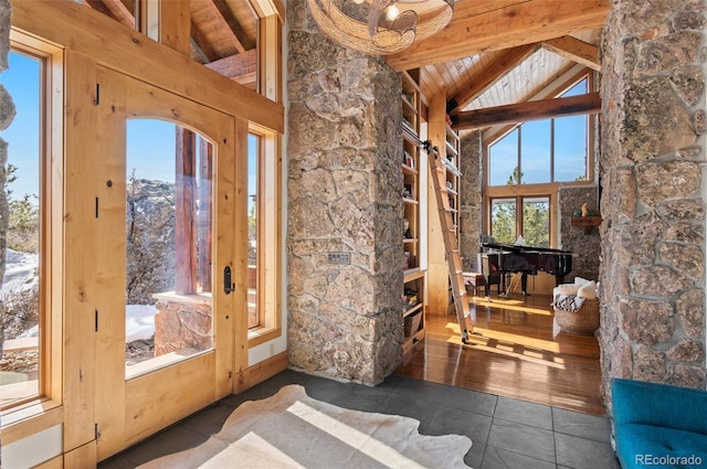 entryway featuring dark tile patterned floors, wooden ceiling, high vaulted ceiling, and beamed ceiling