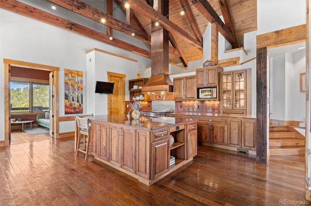 kitchen featuring a kitchen breakfast bar, a center island, high vaulted ceiling, and beamed ceiling