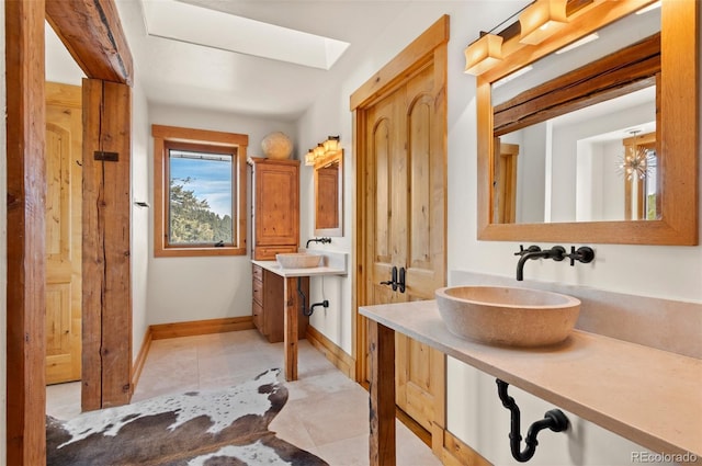 bathroom featuring vanity, tile patterned floors, and a skylight