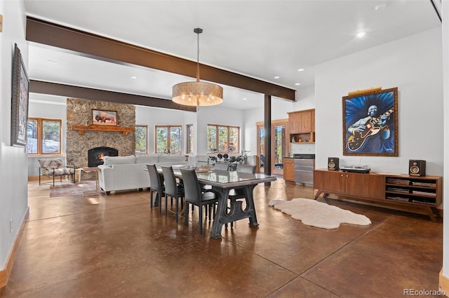 dining space with beamed ceiling and a fireplace