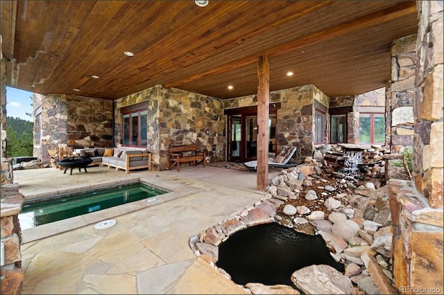 view of swimming pool with a patio and an outdoor living space with a fireplace