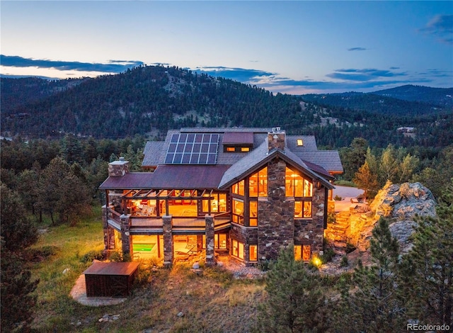 back house at dusk with solar panels and a mountain view