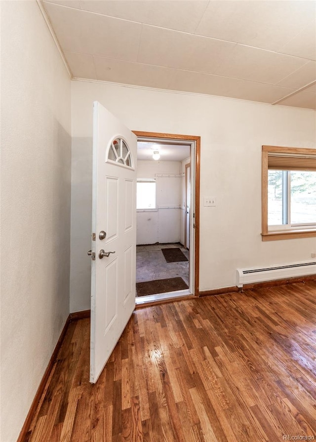 entrance foyer featuring dark wood-type flooring and a baseboard heating unit