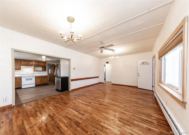 unfurnished living room with baseboard heating, ceiling fan with notable chandelier, and dark hardwood / wood-style floors