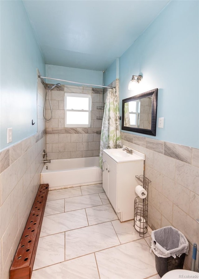 bathroom with vanity, shower / bath combination with curtain, and tile walls