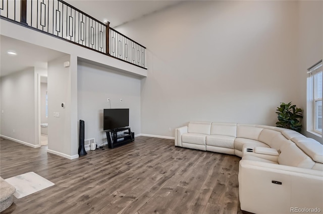 living room featuring wood-type flooring and a high ceiling