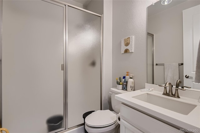 bathroom with vanity, toilet, and a shower with shower door