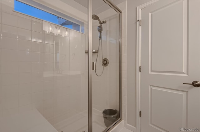 bathroom with a shower with door