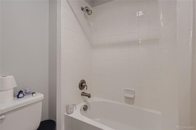 bathroom featuring toilet and tiled shower / bath